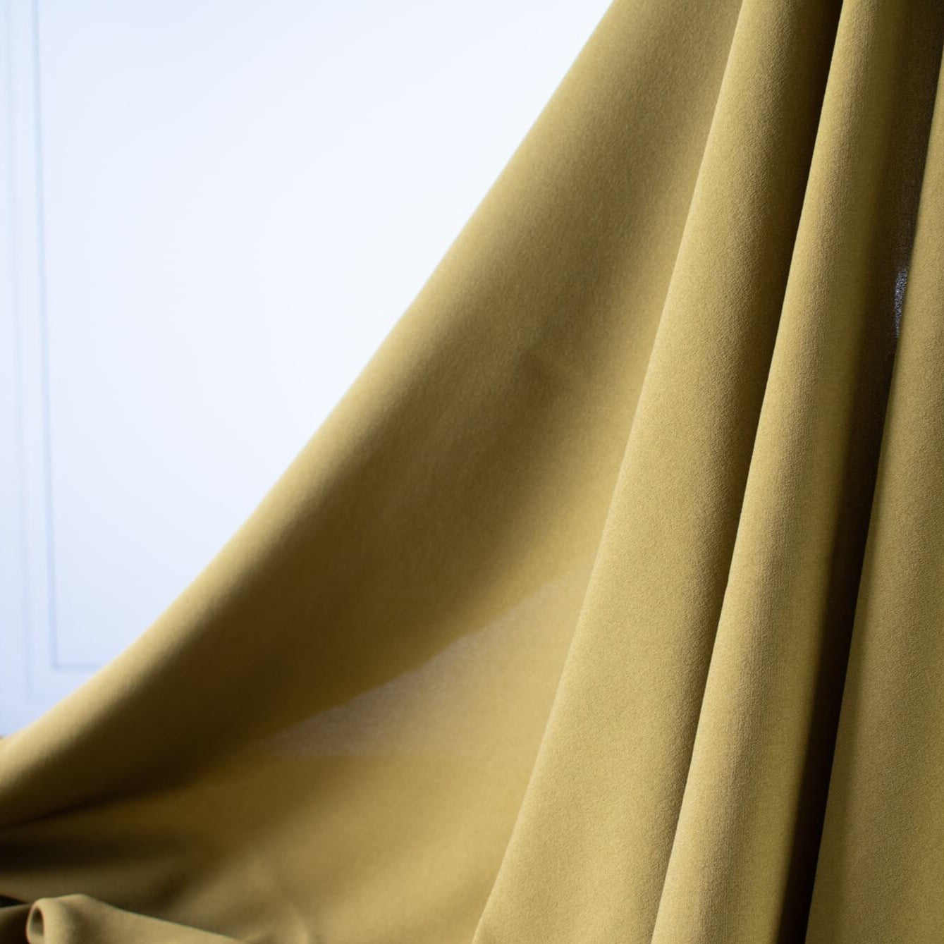 NYC Designer Couture silk crepe de chine in a fantastic width. This mustard green color will bring any of your neutrals a great pop of color! Photo of fabric drape.