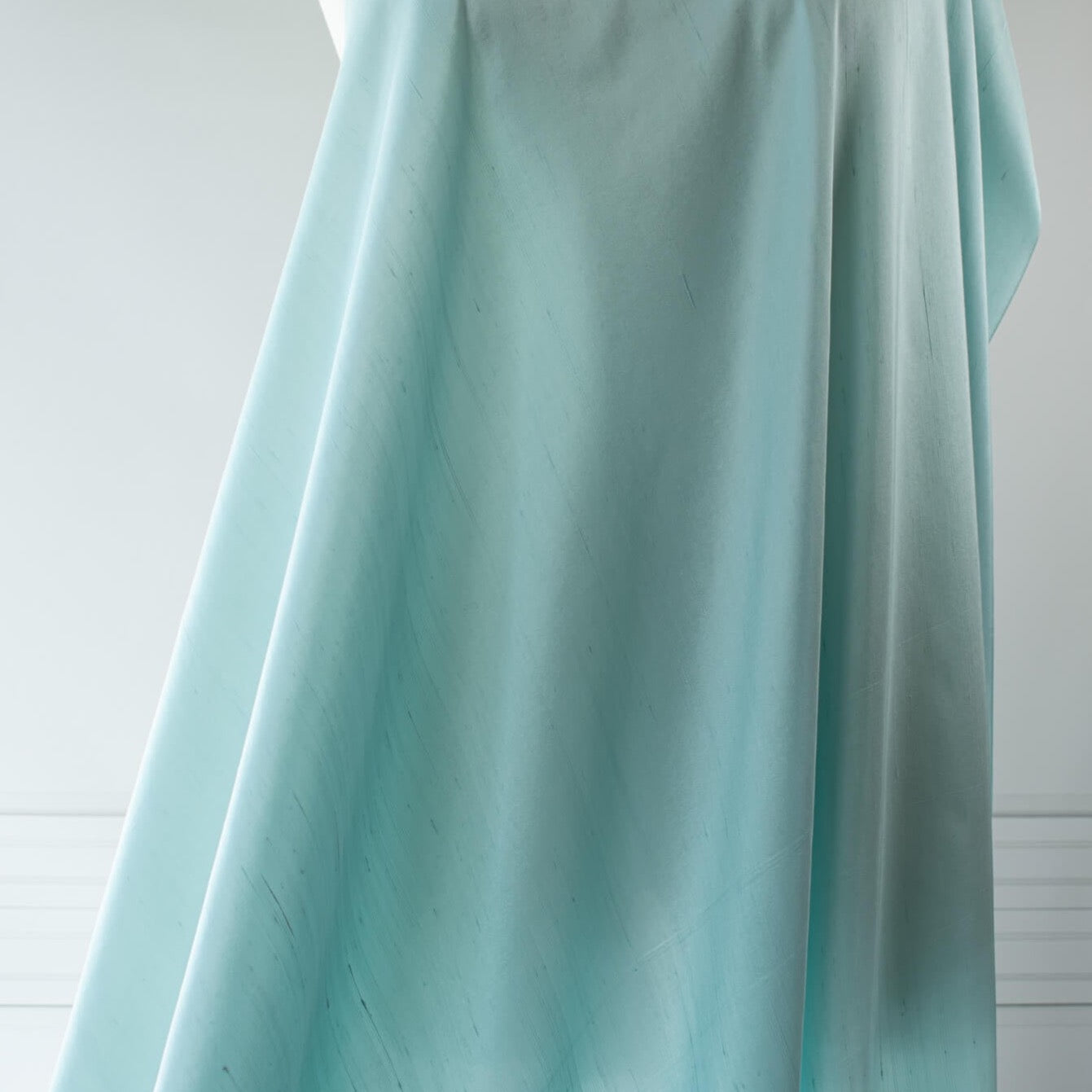 Elegant and dreamy this crystal blue, light weight, silk shantung from a Beverly Hills Couture house is lustrous with a soft slightly textured hand. The suppleness of this silk just feels good against your skin and would make an elegant dress, skirt, gown, suit or top. Image of fabric drape.