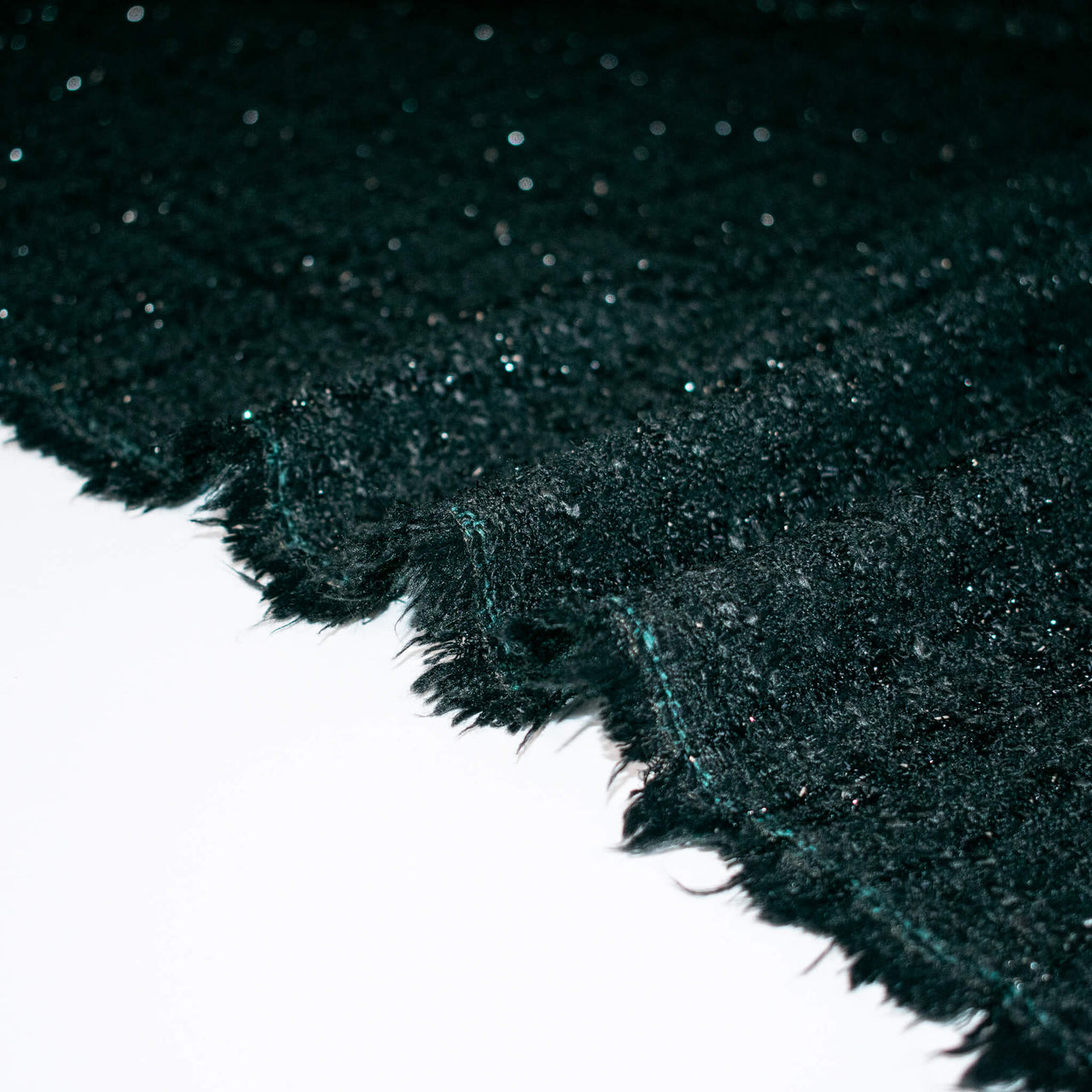 Designer Black boucle fabric close up. of selvedge.