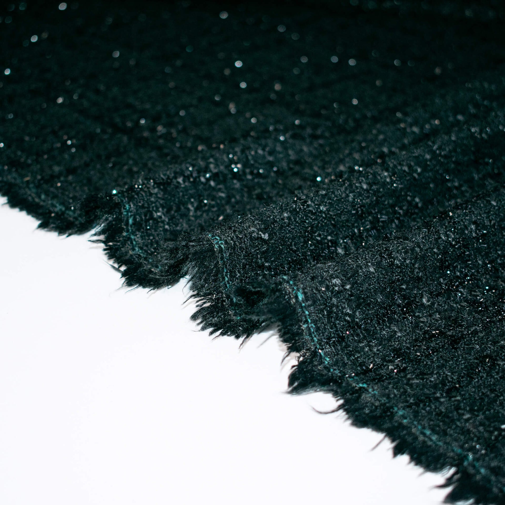 Designer Black boucle fabric close up. of selvedge.