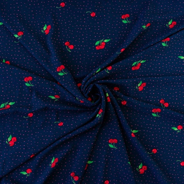 Have some fun with our navy and pink polka dot designer deadstock fabric by the yard adorned with vibrant red cherries. Made from high-quality polyester crepe, this fabric has a textured hand, lovely drape, and a vintage vibe. Image of fabric body.