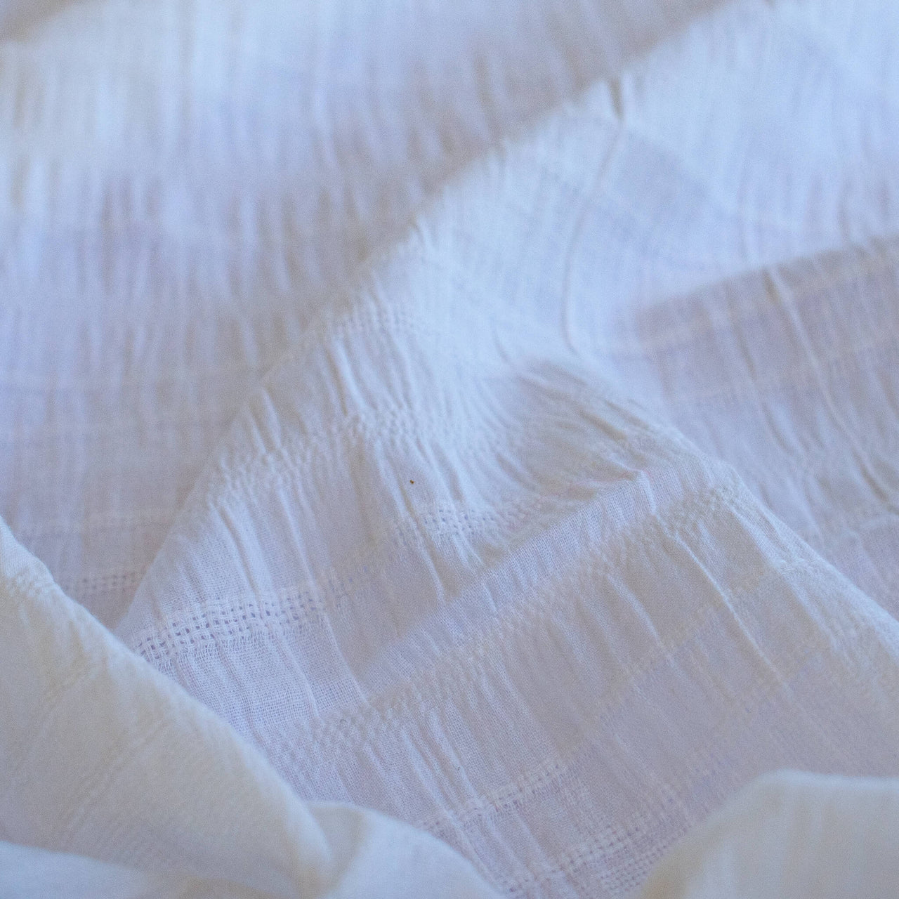 Close-up of white dimity designer fabric with a textured pattern