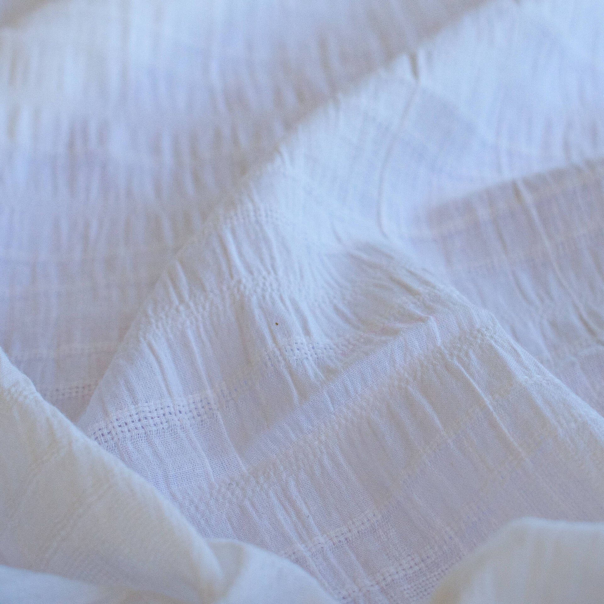 Close-up of white dimity designer fabric with a textured pattern