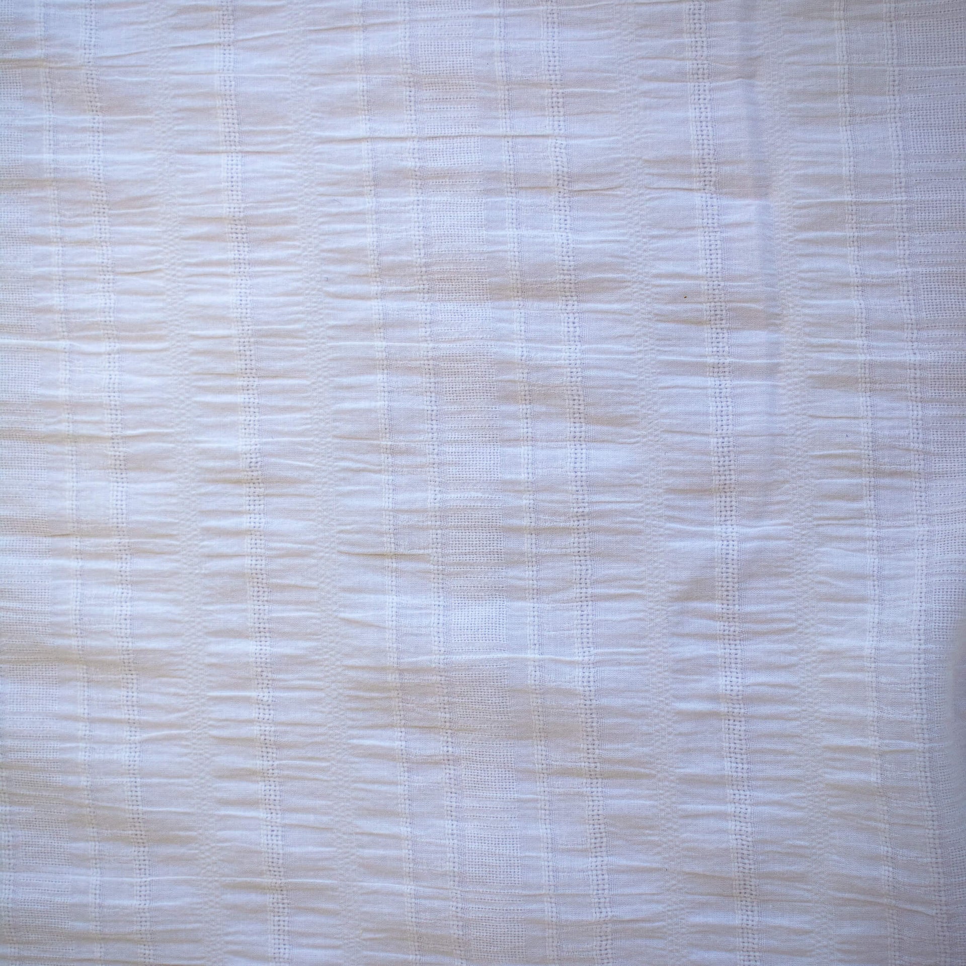 Close-up of white dimity designer fabric with a textured pattern