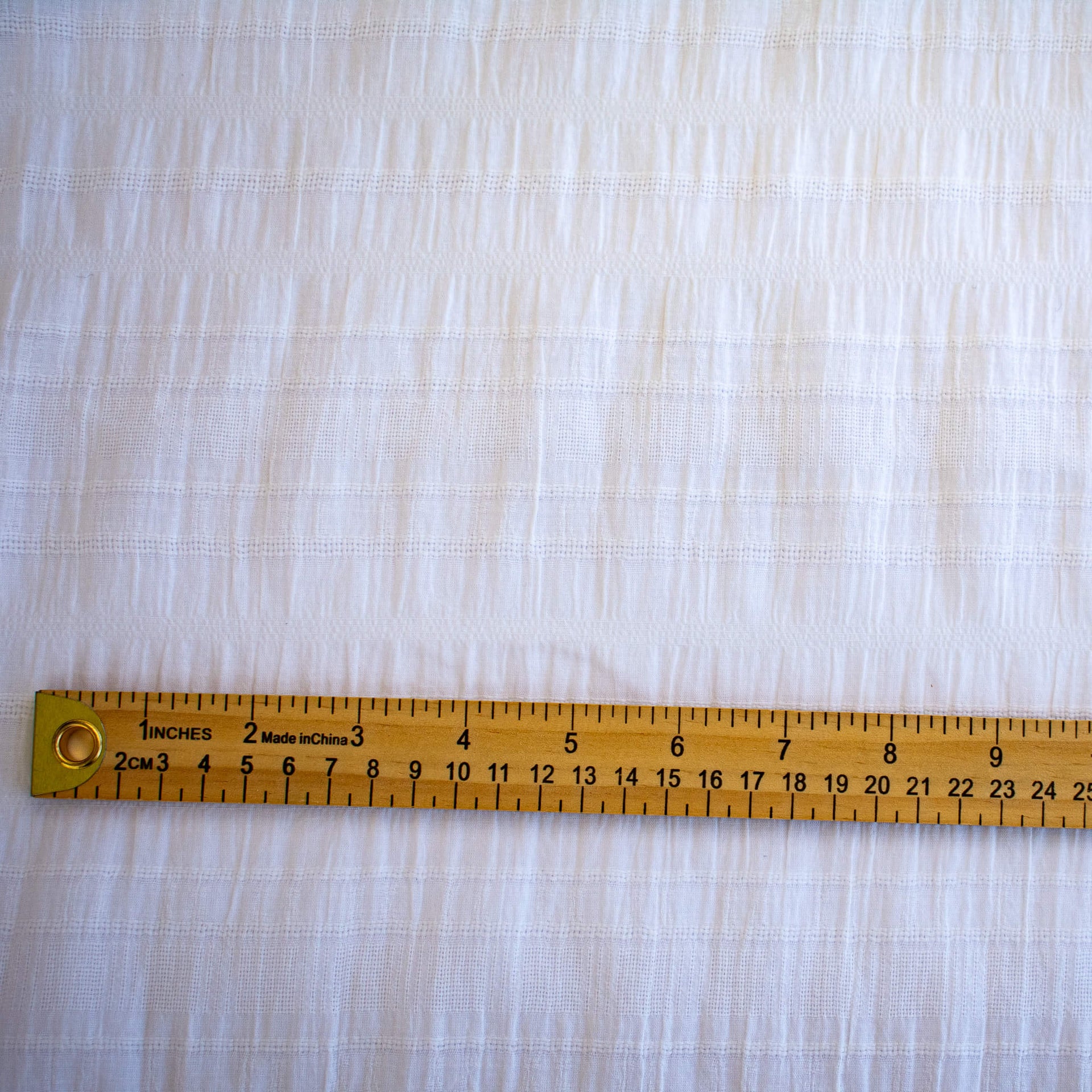 White dimity designer fabric with a ruler for pattern scale