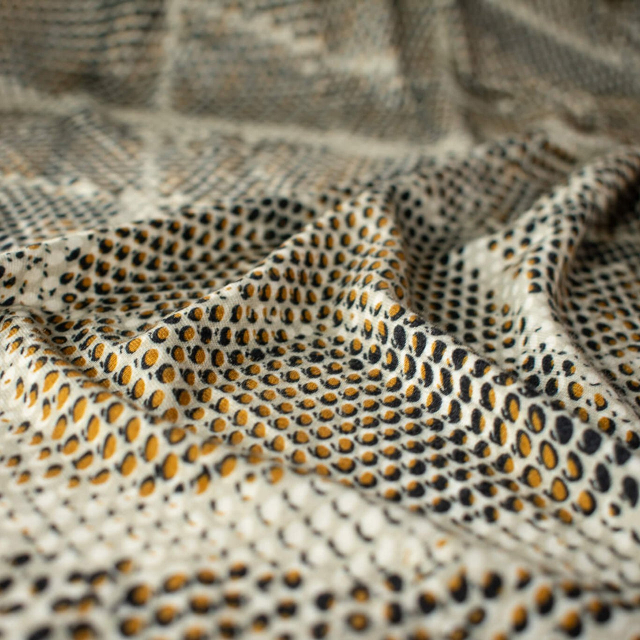 Italian Geometric Animal Print knit fabric by the yard directly from Ratti, the renowned mills know for its excellence in textiles. The elegant shades of browns and tans make it perfect for a sophisticated knit top or as a versatile choice for the latest designer wrap dress. Close up image.