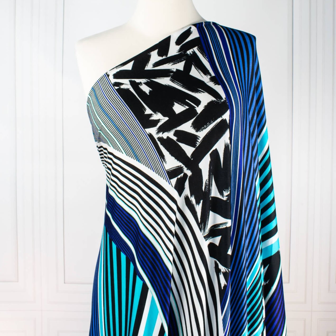 Italian Abstract knit fabric by the yard. The soft hand and gorgeous drape is comfortable and stylish. Be your own designer and create something uniquely your own by taking advantage of the figure flattering print design! Image of fabric draped on dressform.