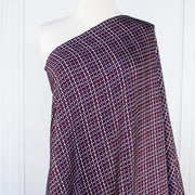 Close up image of fabric on dressform. Italian Viscose Satin Modern Geometric Print designer deadstock fabric by the yard. From the Italian mills, enjoy a sophisticated geometric print of small squares in shades of purple highlighted by an ivory background. A cool smooth hand and satiny sheen is perfect for creating a top or dress that can take you from day to evening.