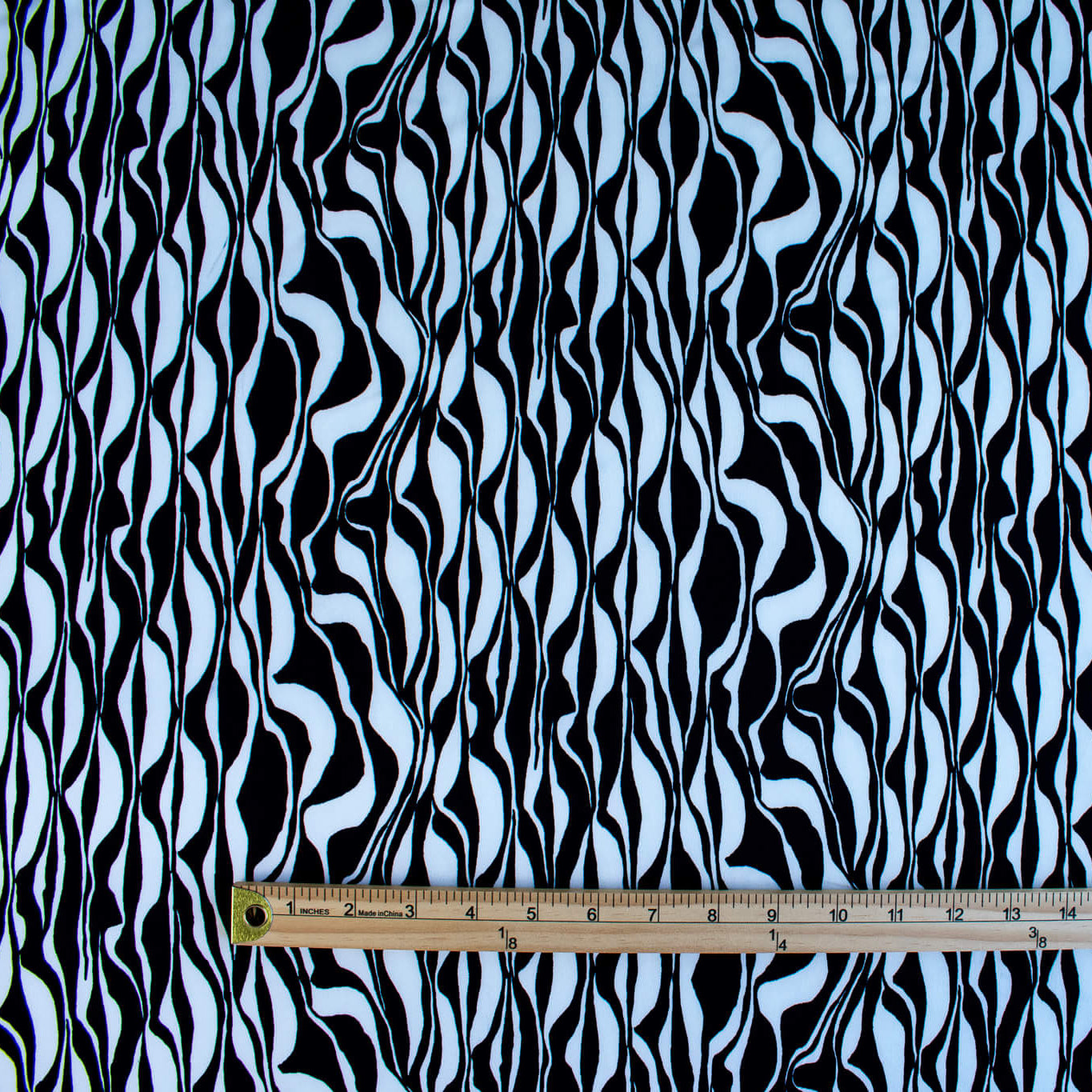 Image with ruler for pattern scale of  Black and Ivory Italian ITY jersey knit fabric by the yard