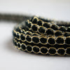 Create a luxurious touch of couture with our vintage trim as it’s metallic gold threading elegantly encircles soft black ribbons. It is sure to make any fabric you are working with sophisticated and glamourous. Close up.