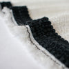 This classic Black Wool Blend Fold-Over Knitted Trim is a timeless choice for couture designs, adding a sophisticated touch of designer embellishment. With its luxurious knitted texture and fold-over shape, this trim will make any look iconic.  Choose your look... this trim can be used flat, or fold-over, which is especially nice for double-sided fabrics! Photo of trim on fabric. Fabric sold separately.