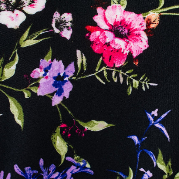 Create a look you’ll love in our timeless black DTY knit fabric with a floral print of pink, white, and purple flowers and soft green leaves. A gorgeous knit with a soft hand and fluid drape, perfect for making a garment that flatters!  Close up image of fabric.