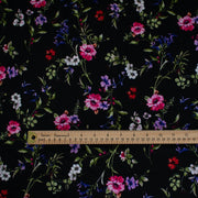 Create a look you’ll love in our timeless black DTY knit fabric with a floral print of pink, white, and purple flowers and soft green leaves. A gorgeous knit with a soft hand and fluid drape, perfect for making a garment that flatters!  Image of fabric with ruler to show scale.