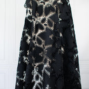 Sourced from a bridal and evening wear couture house comes this chic designer deadstock guipure lace fabric by the yard - a must have for any fashionista. The design showcases inky black maple leaves surrounded by eyelets and a double scalloped border, while the spaced thread bars (or brides) offer flexibility for incorporating the motif into your project. Image of fabric on dressform.