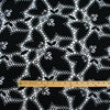 Sourced from a bridal and evening wear couture house comes this chic designer deadstock guipure lace fabric by the yard - a must have for any fashionista. The design showcases inky black maple leaves surrounded by eyelets and a double scalloped border, while the spaced thread bars (or brides) offer flexibility for incorporating the motif into your project. Image of fabric with ruler for scale.