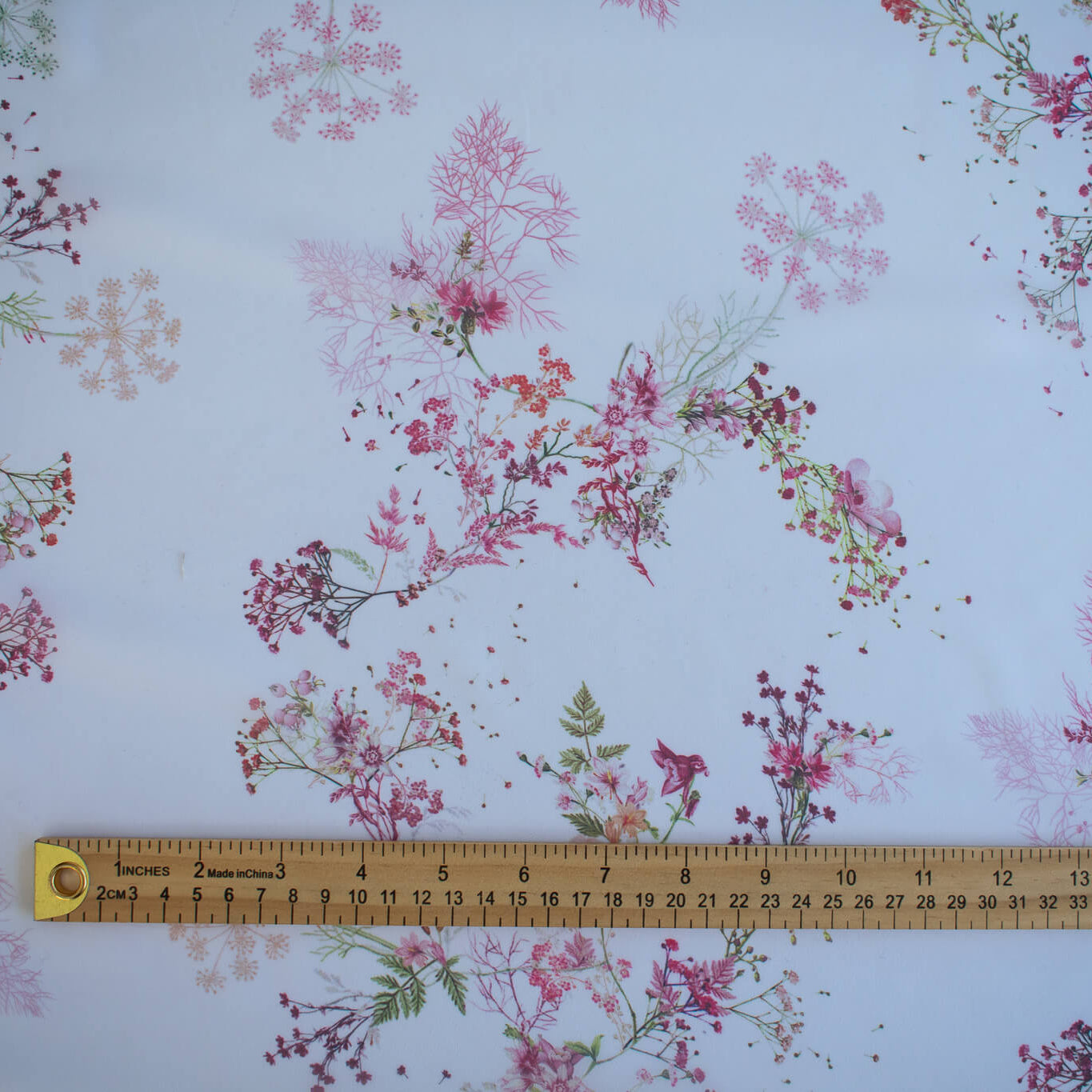 Floral Couture designer soft white silk chiffon fabric with pink flowers and green leaves with ruler for pattern scale