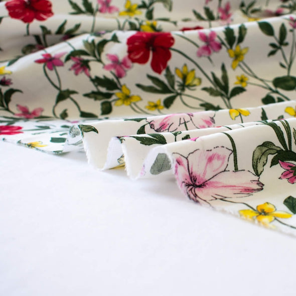"Inspire" a flair for the dramatic with this Floral Cotton Sateen Shirting fabric by the yard! Unapologetically bold with its red, yellow, and pink flowers on a soft white background, it's sure to bring a sparkle to your wardrobe! Cotton sateen offers a luxurious sheen and smooth hand. Image of fabric selvedge.