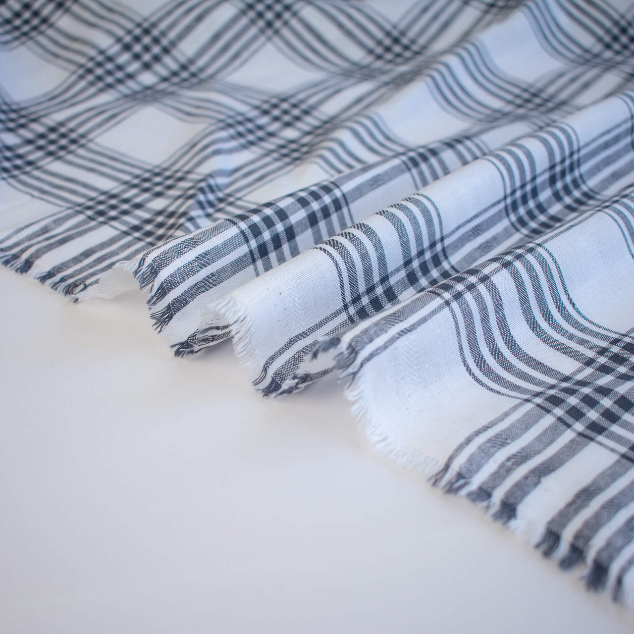 Plaid cotton gauze fabric with blue and white stripes on a light background