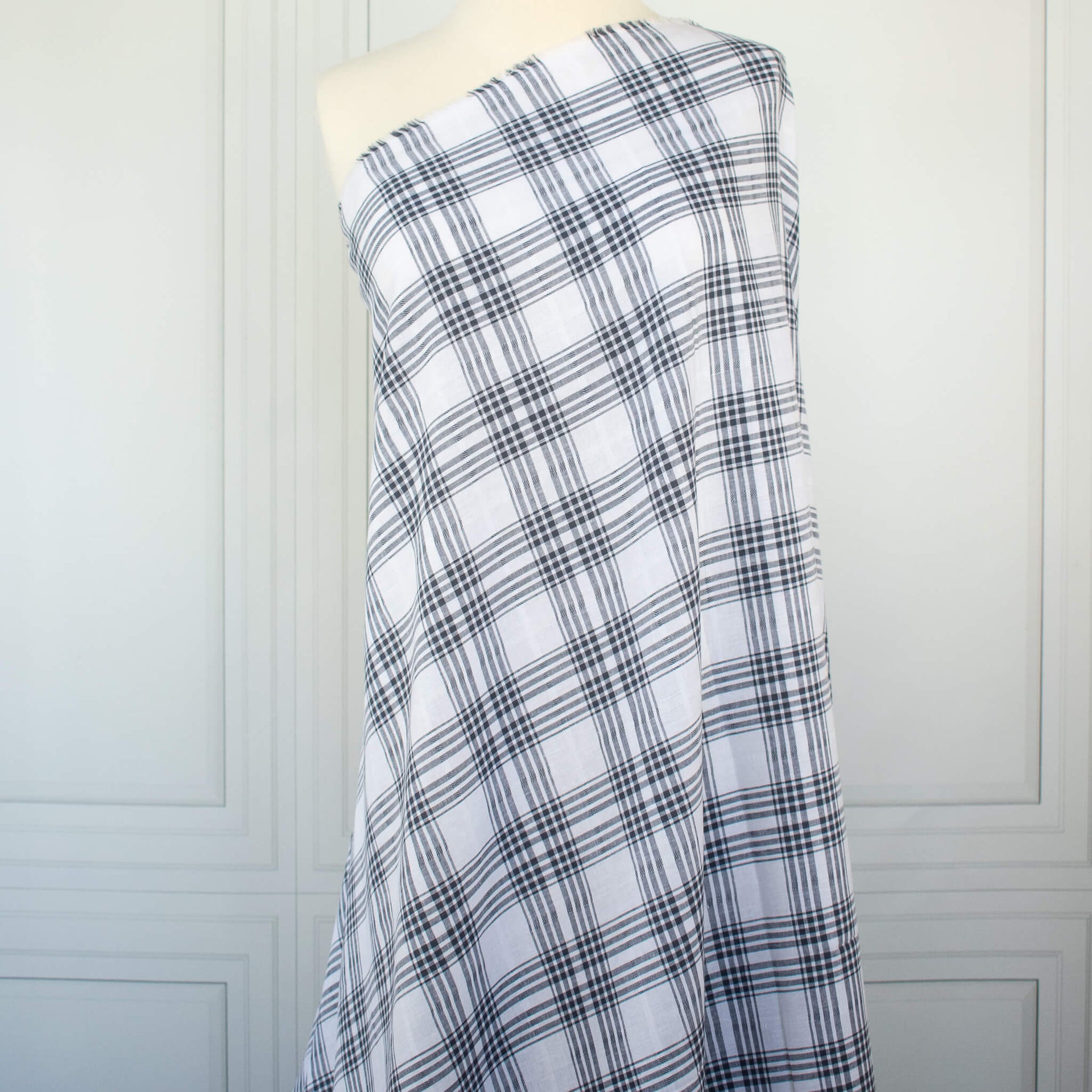 Plaid cotton gauze fabric draped over a mannequin on a white background