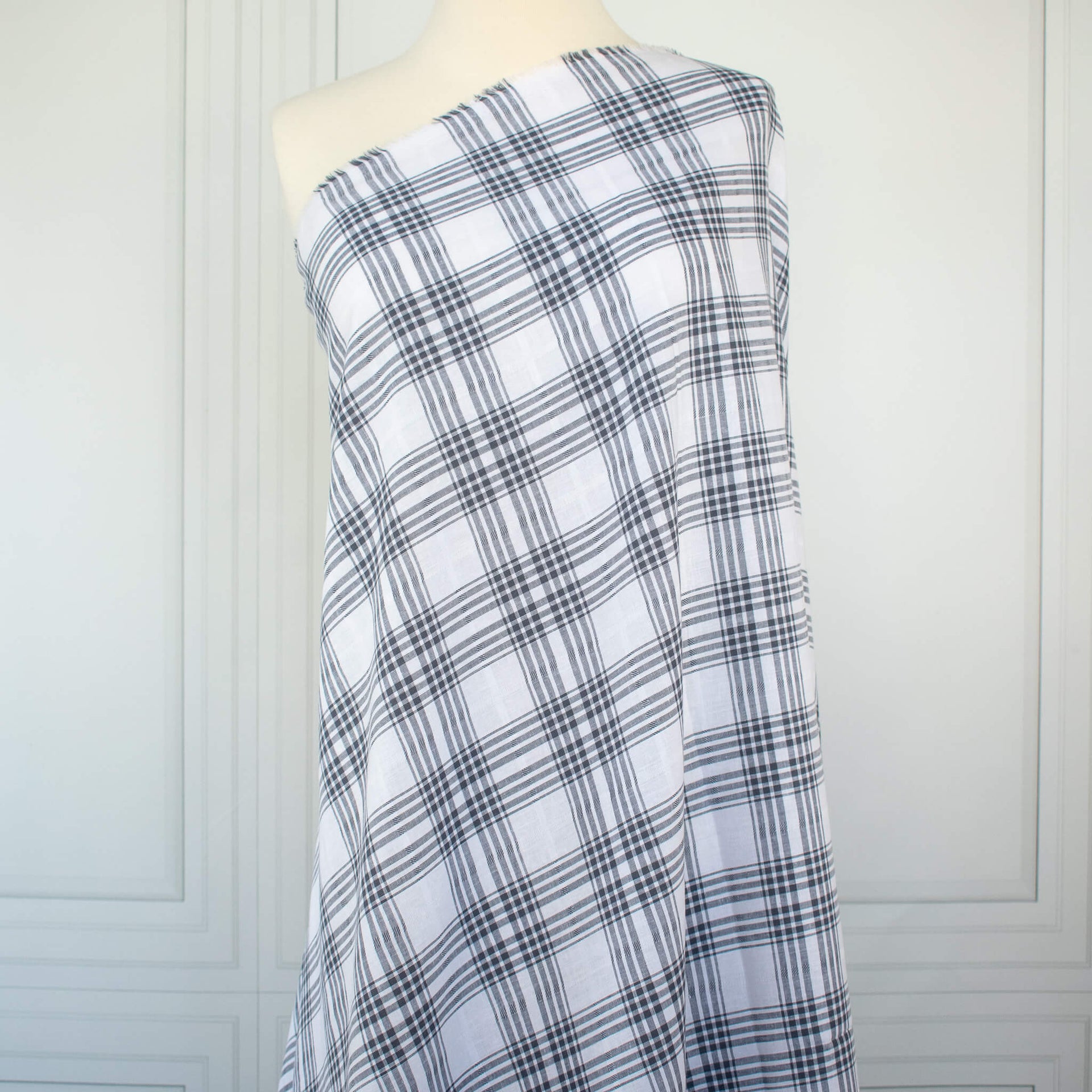 Plaid cotton gauze fabric draped over a mannequin on a white background