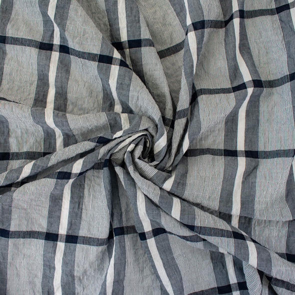 modern, navy blue and white plaid high-end designer cotton fabric. Photo of fabric twirled to demonstrate body.
