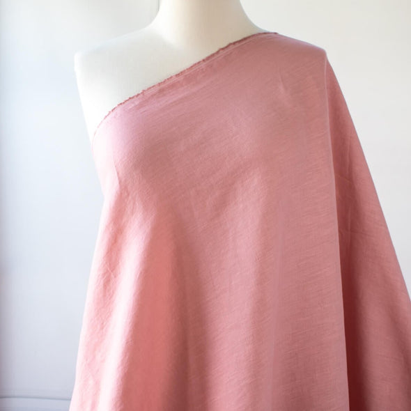 Enjoy the comfortable and luxurious feel of this designer 100% Linen fabric by the yard. This fine fabric features a classy soft rose color and is sure to inspire your 'Me Made' projects.  Photo of fabric draped on dressform.