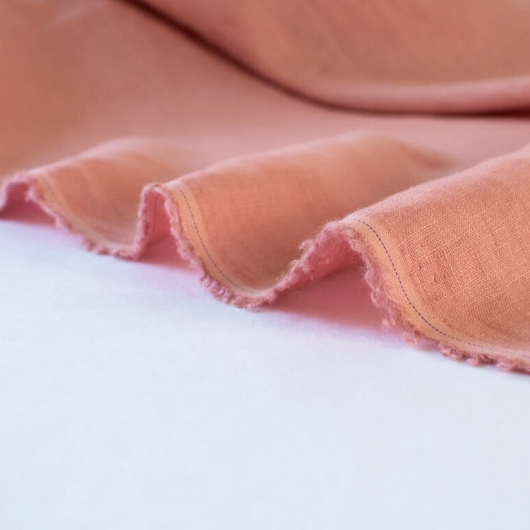 Enjoy the comfortable and luxurious feel of this designer 100% Linen fabric by the yard. This fine fabric features a classy soft rose color and is sure to inspire your 'Me Made' projects.  Close up photo of selvedge.