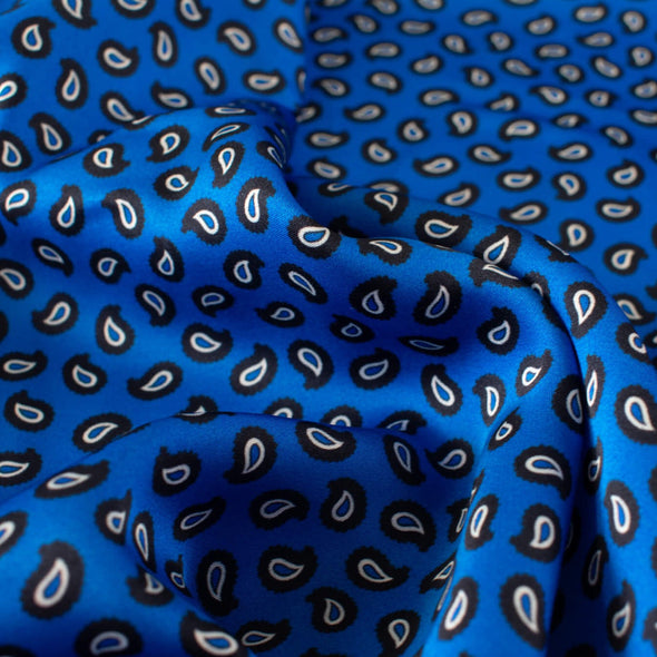 Designer Blue paisley Italian satin challis with a fluid drape and satiny softness  from the Parisian luxury designer M@je. Close up image.