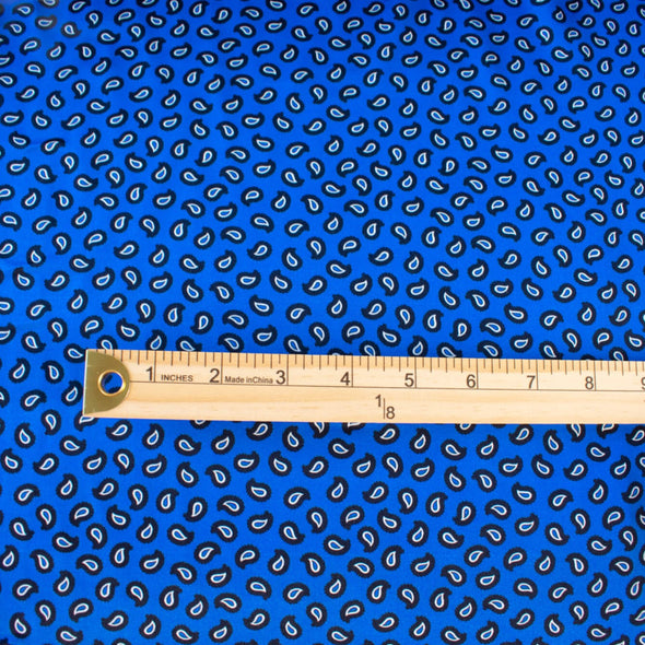 Designer Blue paisley Italian satin challis with a fluid drape and satiny softness from the Parisian luxury designer M@je. Image of fabric scale with ruler.