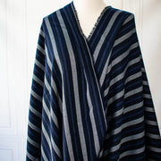 Deveaux France luxury yarn-dyed woven striped fabric featuring a crepe like texture and soft drape. Fabric with white and cobalt blue vertical stripes. Image of fabric draped on dressrform.