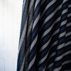 Deveaux France luxury yarn-dyed woven striped fabric featuring a crepe like texture and soft drape. Fabric with white and cobalt blue vertical stripes. Image of fabric draped on dressrform