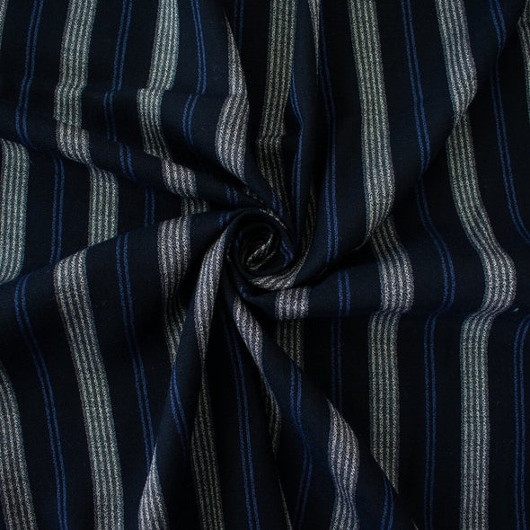 Deveaux France luxury yarn-dyed woven striped fabric featuring a crepe like texture and soft drape. Fabric with white and cobalt blue vertical stripes. Image of fabric in soft folds.