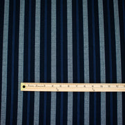 Deveaux France luxury yarn-dyed woven striped fabric featuring a crepe like texture and soft drape. Fabric with white and cobalt blue vertical stripes. Image of fabric with ruler to show pattern scale.