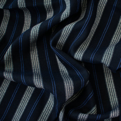 Deveaux France luxury yarn-dyed woven striped fabric featuring a crepe like texture and soft drape close up picture of fabric with white and cobalt blue vertical  stripes.