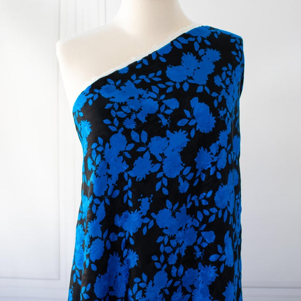 The 'Roses in Blue' Italian Jacquard fabric by the yard is just gorgeous! Luxurious and elegant, a beautiful black viscose fabric featuring a vibrant blue floral design that is sure to get you noticed.  Opaque with a nice drape and body, it is perfect for formal attire or a little something special. Image of fabric draped on dressform.