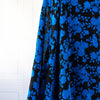 The 'Roses in Blue' Italian Jacquard fabric by the yard is just gorgeous! Luxurious and elegant, a beautiful black viscose fabric featuring a vibrant blue floral design that is sure to get you noticed.  Opaque with a nice drape and body, it is perfect for formal attire or a little something special. Image of fabric drape.