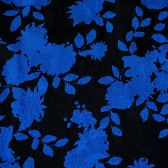 The 'Roses in Blue' Italian Jacquard fabric by the yard is just gorgeous! Luxurious and elegant, a beautiful black viscose fabric featuring a vibrant blue floral design that is sure to get you noticed.  Opaque with a nice drape and body, it is perfect for formal attire or a little something special. Image of fabric highlighting jacquard  design.