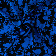 The 'Roses in Blue' Italian Jacquard fabric by the yard is just gorgeous! Luxurious and elegant, a beautiful black viscose fabric featuring a vibrant blue floral design that is sure to get you noticed.  Opaque with a nice drape and body, it is perfect for formal attire or a little something special. Image of fabric swirled demonstrating body.