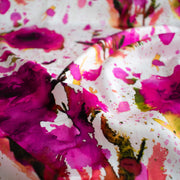 Image of designer Italian satin viscose woven fabric by the yard. Featuring an exquisite watercolor floral pattern of dark pink abstract roses against a soft white background.
