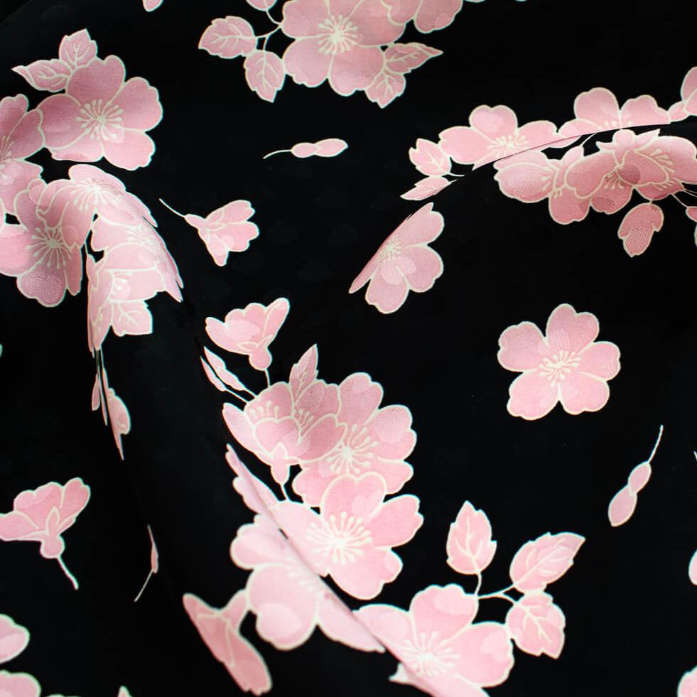 Couture Italian Viscose Floral Jacquard - 'All My Heart'! This stunning designer deadstock fabric by the yard features a gorgeous black base with delicate pink florals and ivory accents. Plus, playful and trending jacquard hearts add a touch of whimsy. 
Featuring a nice drape that falls away from the body and slightly textured hand, you'll find this fabric is perfect for formal attire or a little something special.  Close up image.