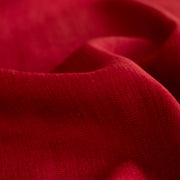 Close up image of Premium Italian linen-viscose blend in a rich burnt carmine hue.