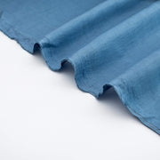 A close-up of Italian linen and viscose blend woven fabric by the yard in a soft Aegean blue. Selvedge