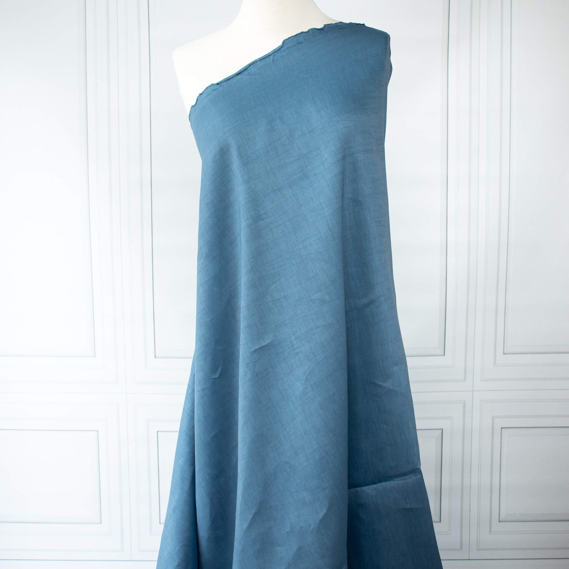 Image of Italian linen and viscose blend woven fabric by the yard in a soft Aegean blue draped on dress form.