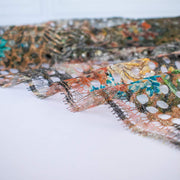 Couture designer deadstock Darquer lace by the yard boasts a playful mix of florals and animal print accentuated by metallic threads in warm gold and copper tones. The unexpected combination of turquoise florals, green leaves, and black-and-white animal print will surely catch some attention. Image of lace edge.