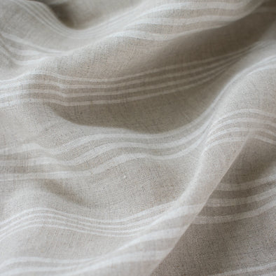 Experience the luxury of European linen fabric in a classic horizontal stripe. This medium weight linen would make a stunning jacket, skirt or pant. Featuring a wide width, textured hand, and sets of wide and narrow off white stripes. Photo of fabric 