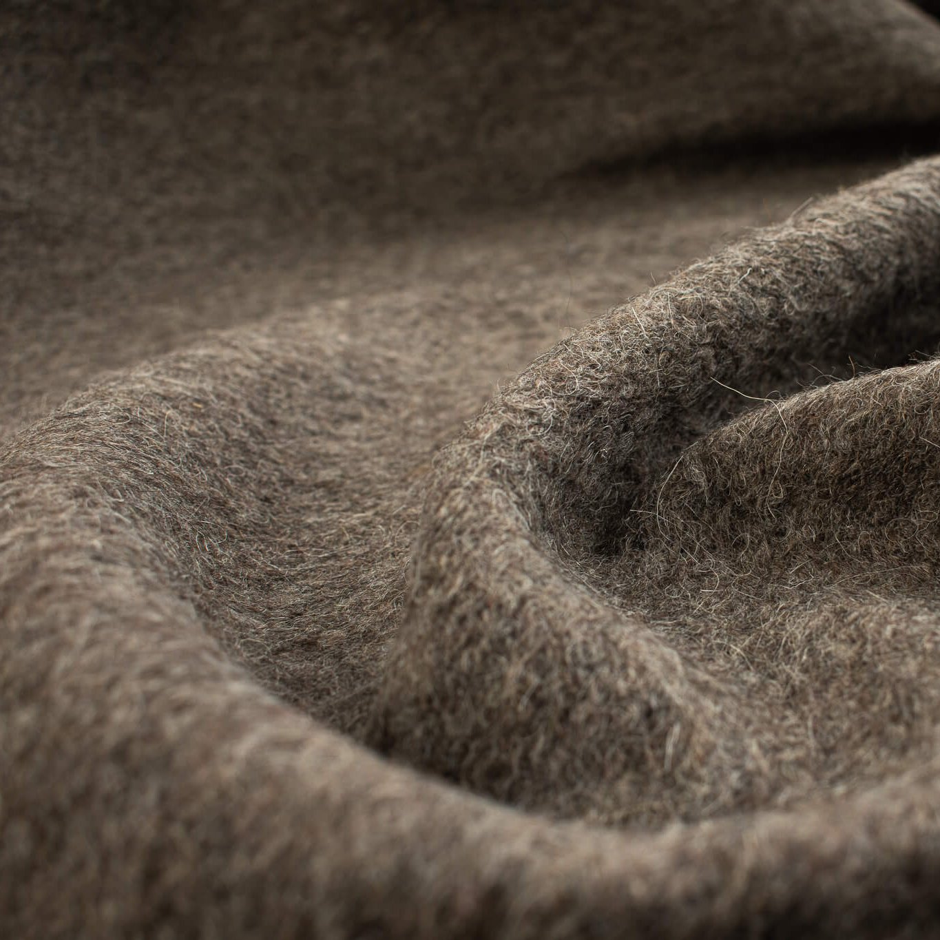 Italian Couture Wool Single Faced designer deadstock knit fabric by the yard in dark taupe and white. Perfect for chilly days this wool knit mimics a fleece with a fuzzy texture on the face and a lightly textured back. Close up image.