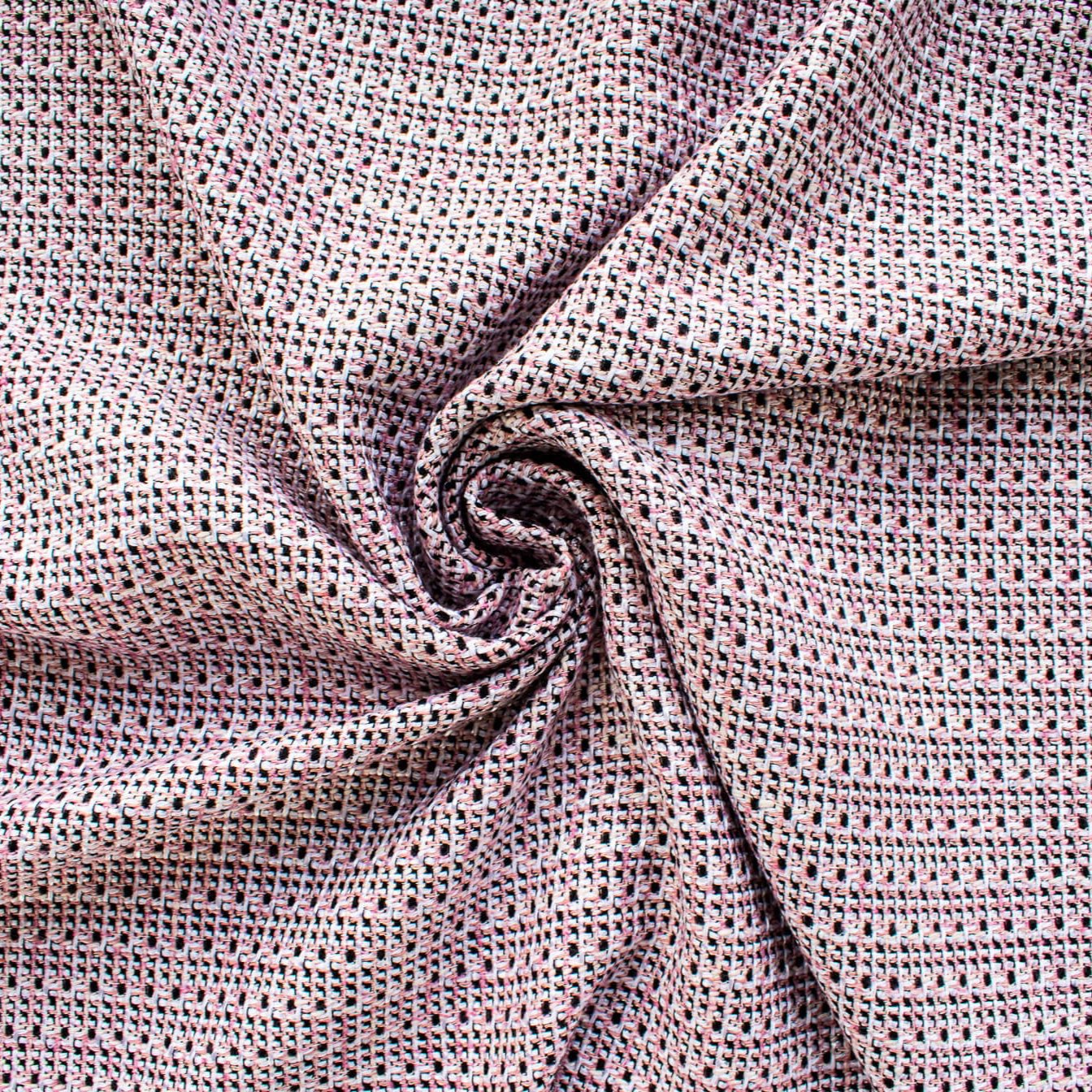 Our Couture Cotton Blend Designer Tweed fabric by the yard will have you 'Blushing' with excitement! Just in from Italy, this Ch@nel tweed is just lovely with its soft hand and elegant drape and features shades of pink, white, black, and red. Image of fabric fullness.