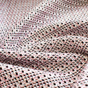 Our Couture Cotton Blend Designer Tweed fabric by the yard will have you 'Blushing' with excitement! Just in from Italy, this Ch@nel tweed is just lovely with its soft hand and elegant drape and features shades of pink, white, black, and red. Close up image.