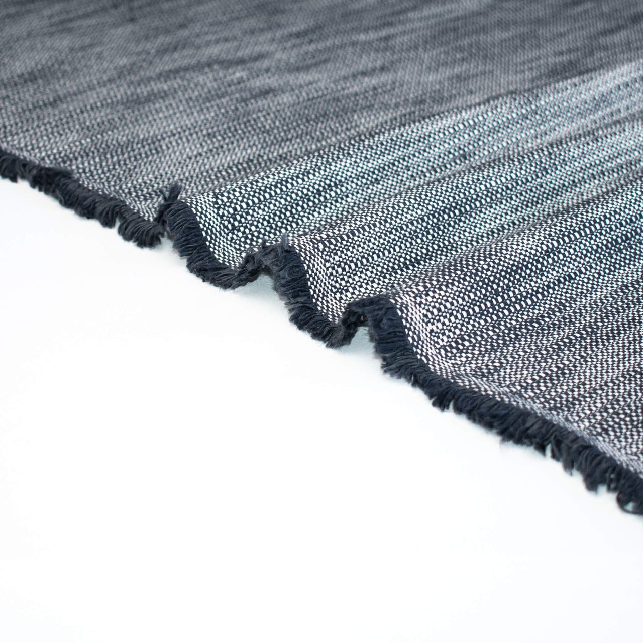 Close-up of blue and white cotton slub fabric and selvedge.