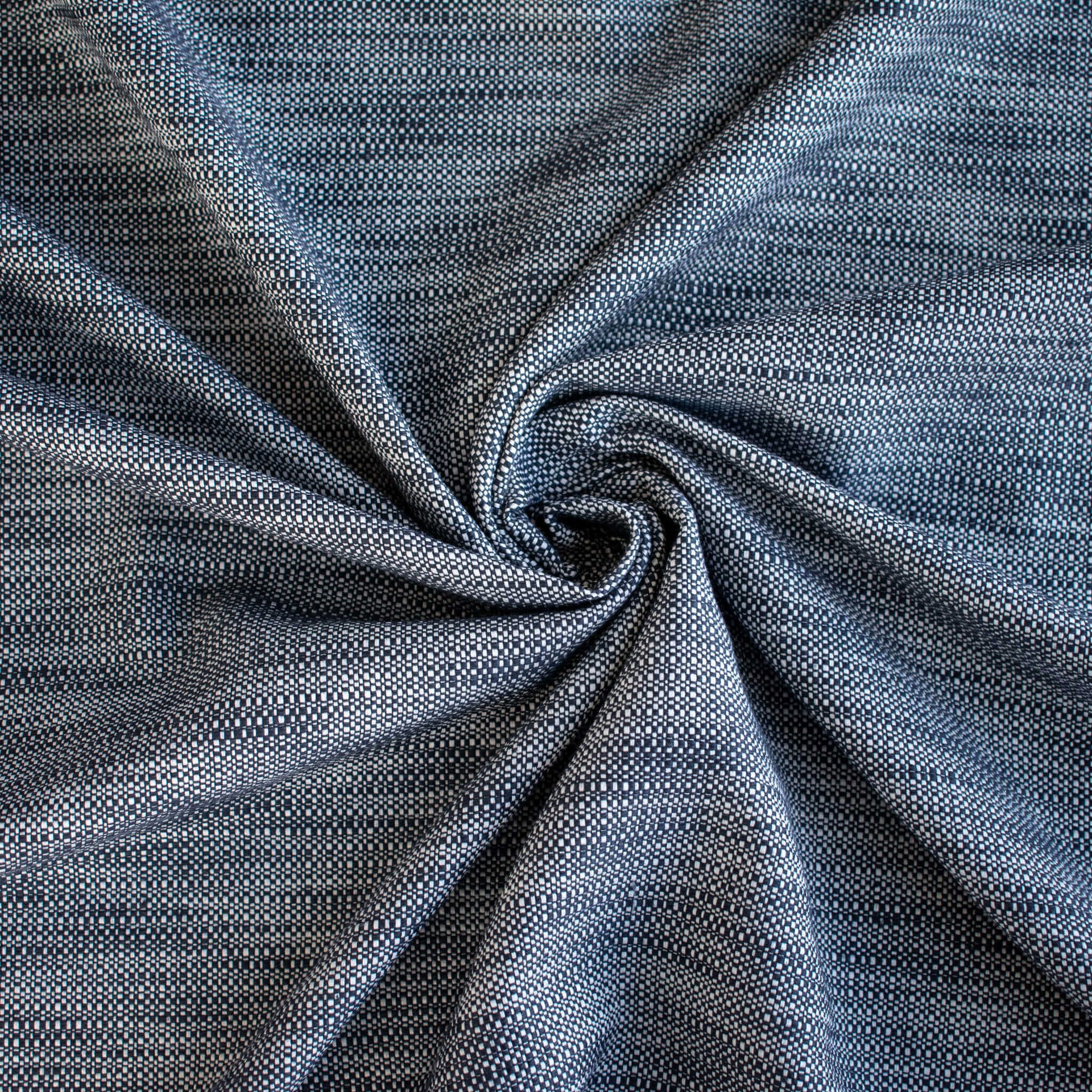 Close-up of blue and white cotton slub fabric swirled to demonstrate body.